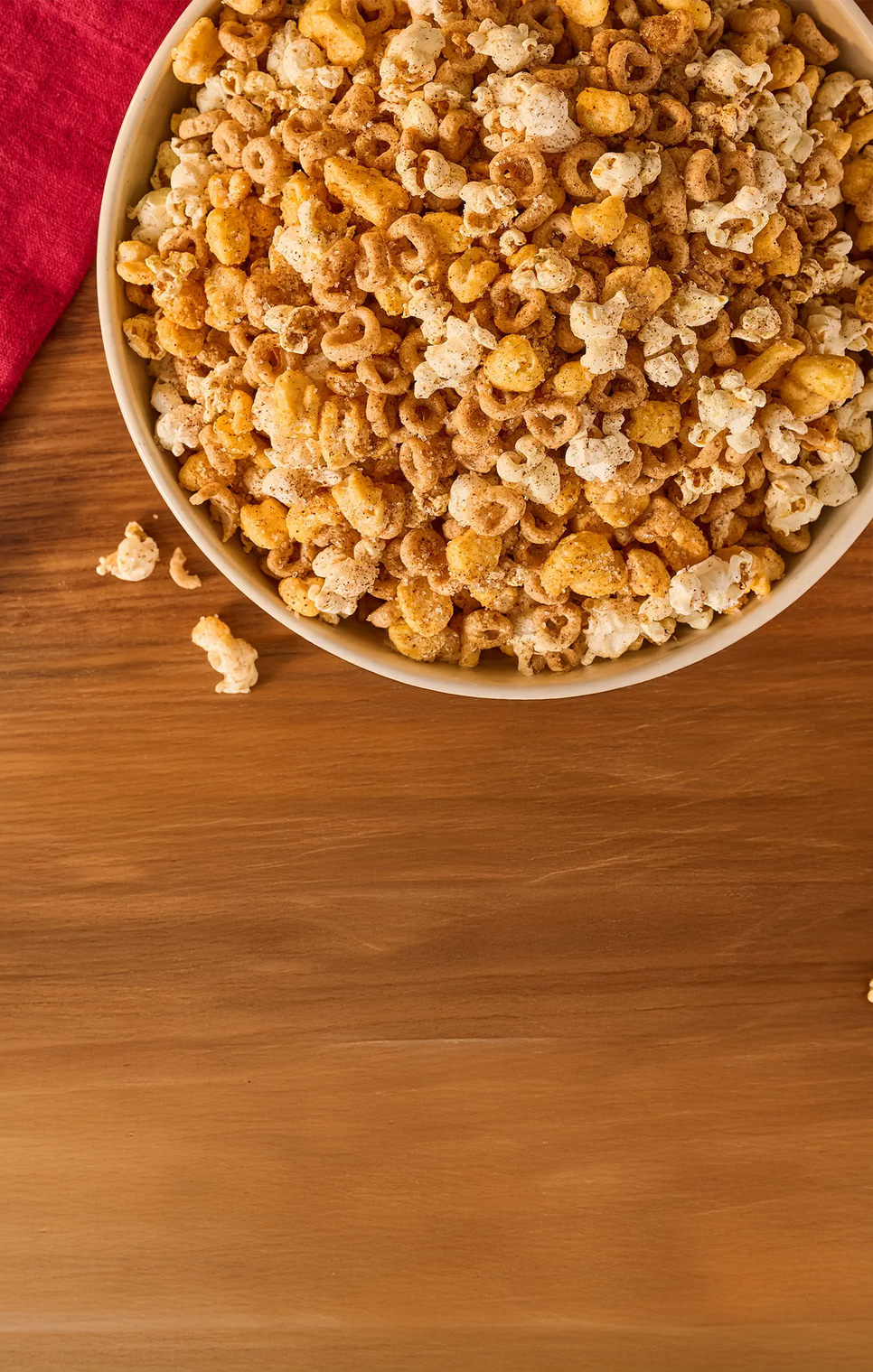  bowl of popcorn on a wooden surface with a red napkin
