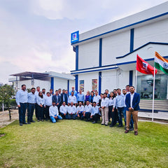 Group of employees gathered outside a McCormick facility with McCormick and India flags.