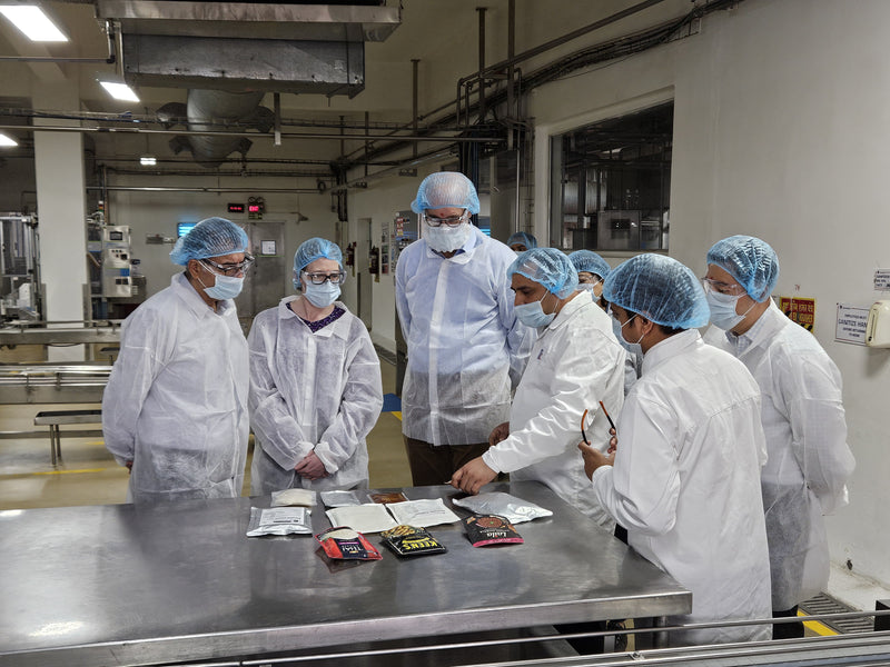 Group of people in a laboratory setting wearing protective gear.