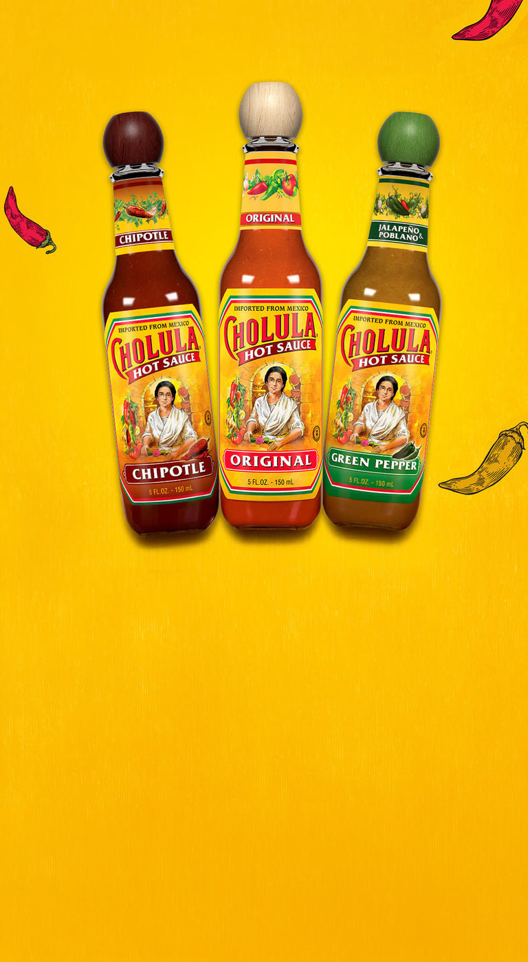 Three bottles of Cholula Chipotle, Original, and Green Pepper hot sauce on a yellow background.