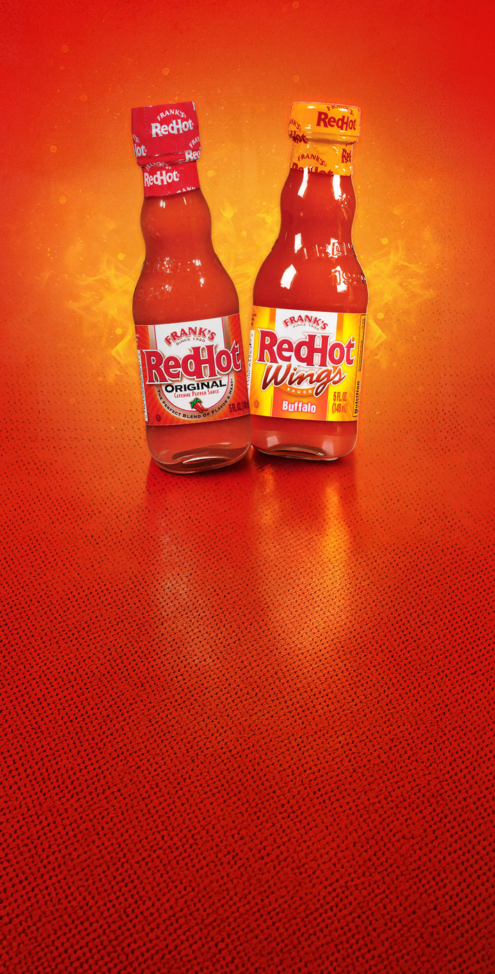 Two bottles of Frank’s RedHot Original and Buffalo Wings hot sauce on a red background.