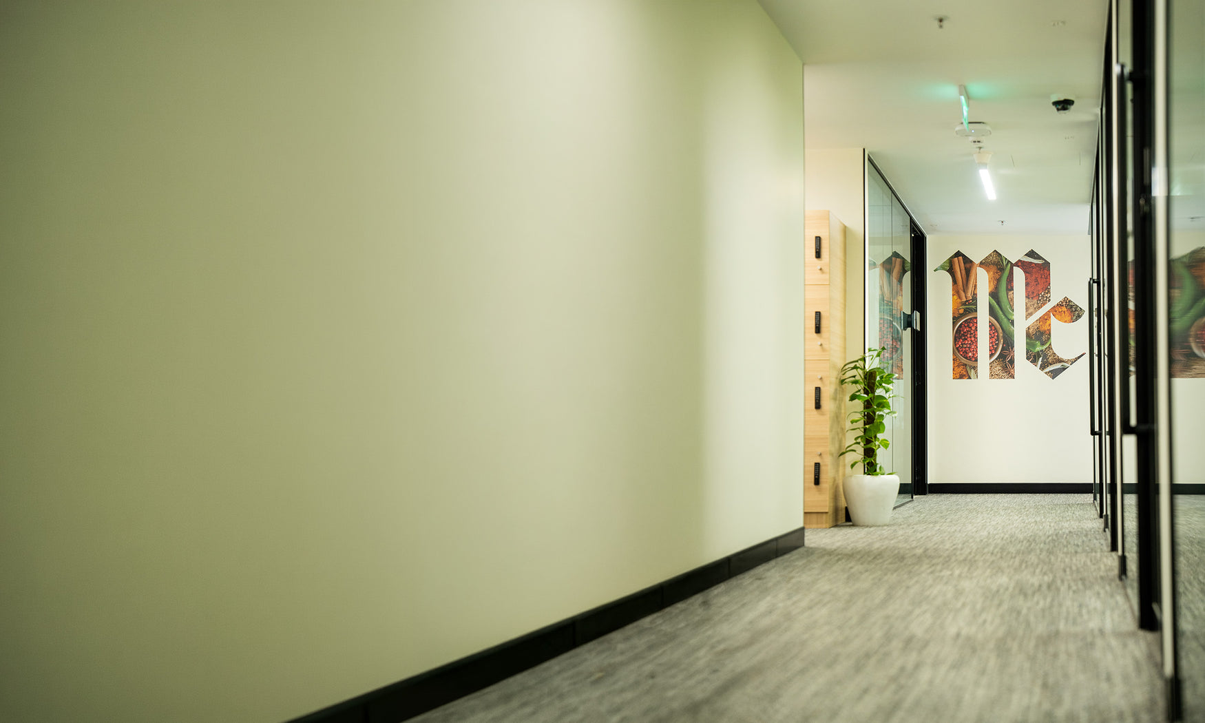 Office hallway with glass walls and a McCormick logo mural featuring spices.