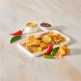 Tray of chips with two dips and peppers on a marble surface