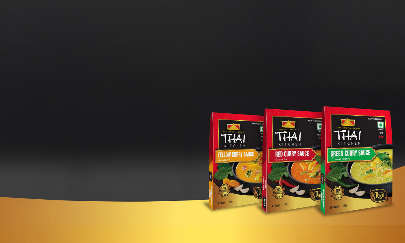 Thai Kitchen Yellow Curry, Red Curry, and Green Curry Sauce packages on a dark background.
